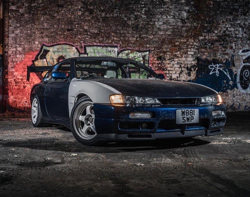 Calvin’s modified Nissan S14 parked in front of a brick wall